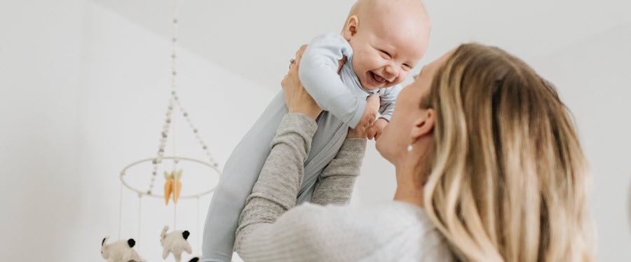 A woman holding her baby above her head